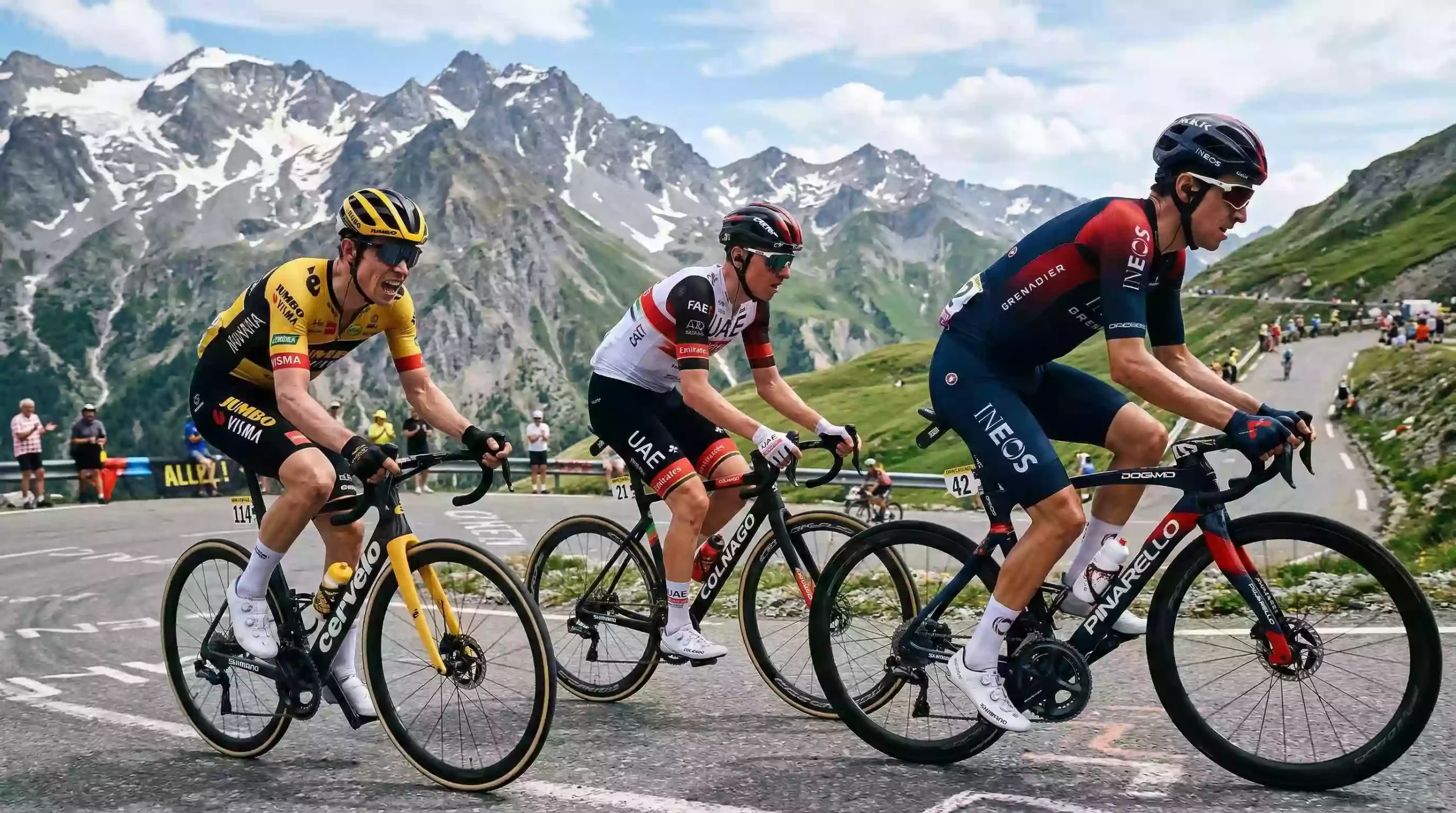 Tres ciclistas profesionales compitiendo en una etapa de montaña del Tour de Francia con paisaje alpino de fondo