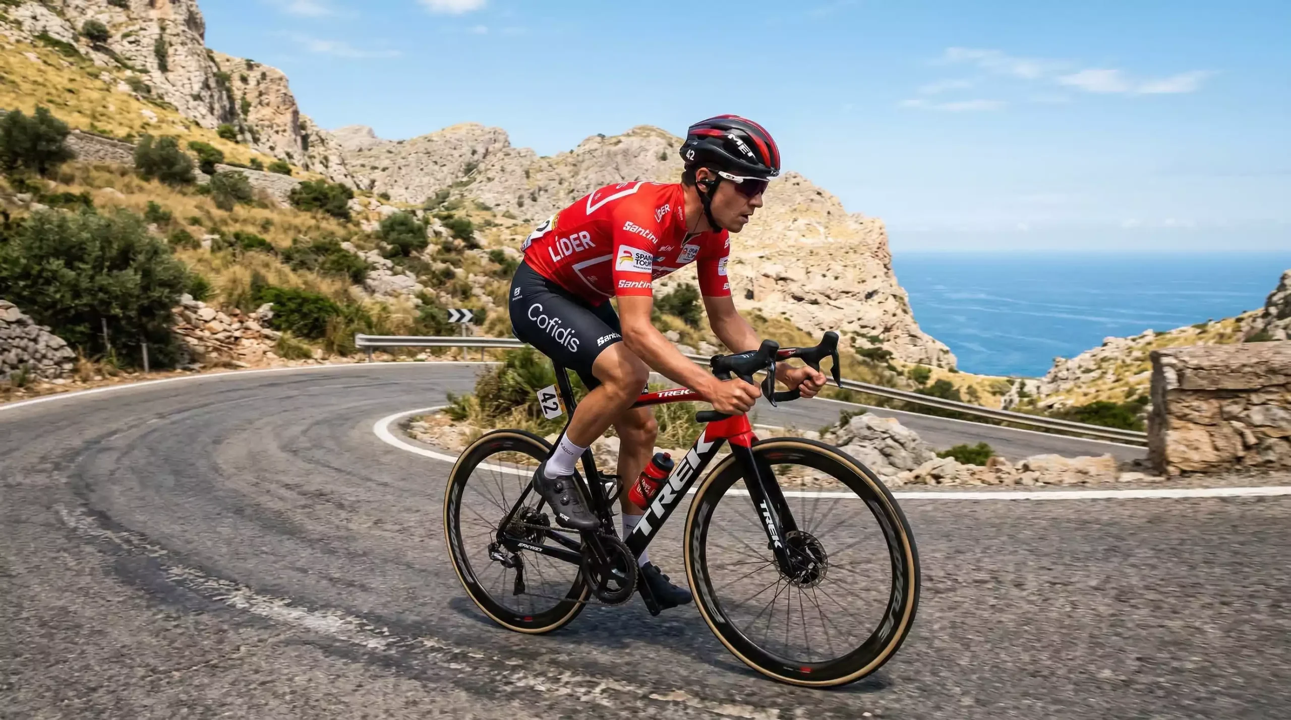 Ciclista con maillot rojo descendiendo un puerto de montaña durante la Vuelta a España