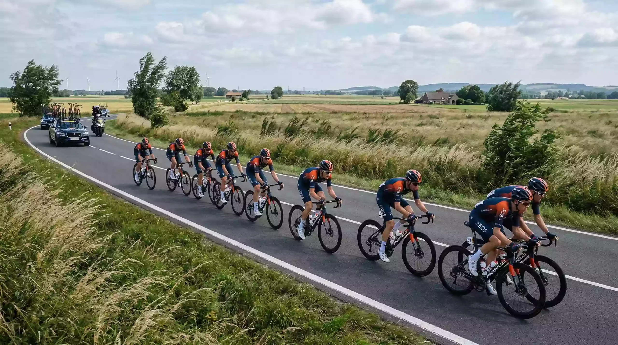 Equipo ciclista WorldTour rodando en formación compacta protegiendo a su líder en una etapa llana